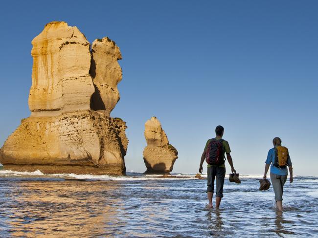 ESCAPE: Couple hike past the Twelve Apostles. Picture: Visit Victoria