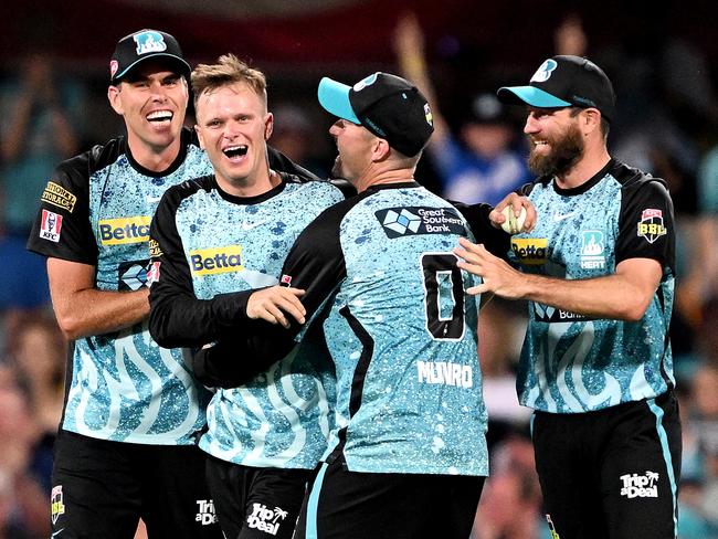 BRISBANE, AUSTRALIA - DECEMBER 27: Matthew Kuhnemann of the Heat celebrates with team mates after taking the wicket of Oliver Davies of the Thunder during the BBL match between the Brisbane Heat and Sydney Thunder at The Gabba, on December 27, 2023, in Brisbane, Australia. (Photo by Bradley Kanaris/Getty Images)