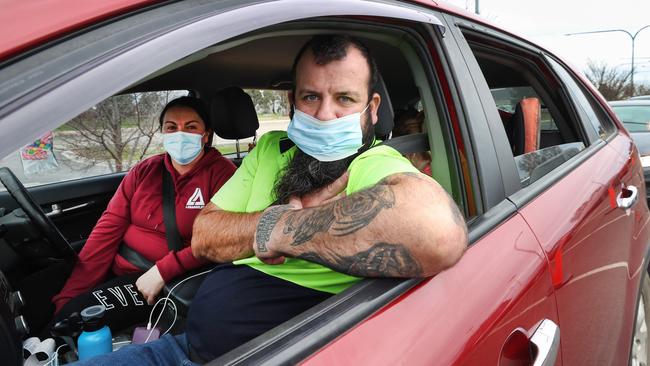 David and Lisa Stevens waiting in line with their children for a test in Shepparton. Picture: David Caird