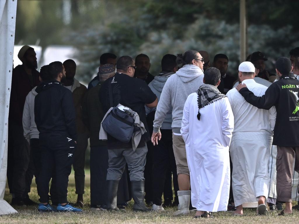 People gather at the burial ground where funerals for victims are set to take place. Picture: AFP