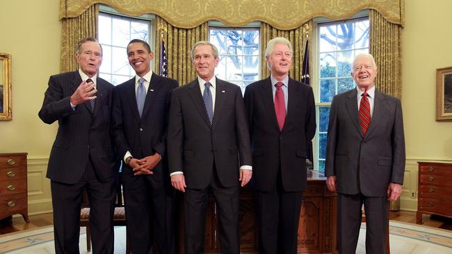 Then president George W. Bush, with his father and former president George HW Bush, meet president-elect Barack Obama, Bill Clinton and Jimmy Carter in the Oval Office in 2009. Picture: Getty Images