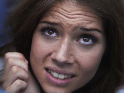 Shot of a fearful young woman feeling trapped by the crowd