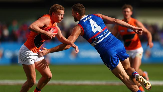 Young Giant Ryan Angwin gets around Bulldogs captain Marcus Bontempelli. Picture: Graham Denholm/Getty Images