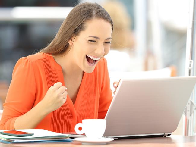 IMAGES FOR NEWS.COM.AU COMMENT MODERATION STORY - THIS IS 'TRISH' -  Single excited entrepreneur receiving good news on line in a laptop sitting in a restaurant terrace  Picture: istock