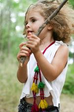 Hippie chic curly girl playing with a tree branch