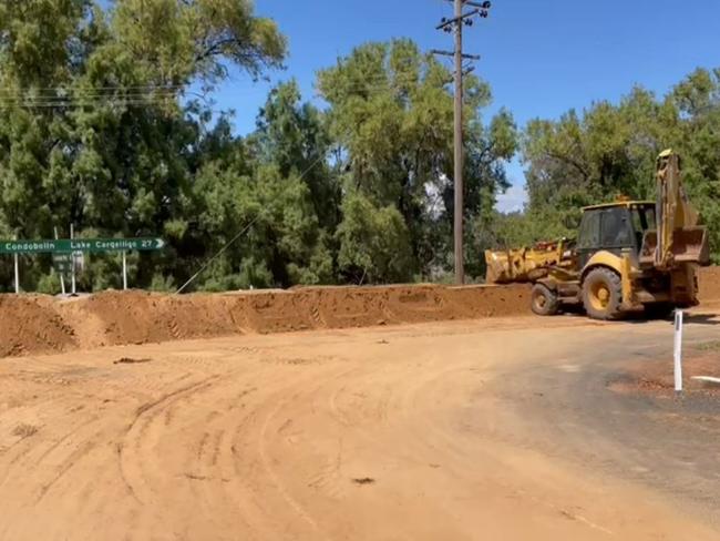 Locals and emergency services have constructed a hundreds-metre long dirt mound to protect their tiny community of Eubalong from rising flood waters. Picture: Erin Dooley