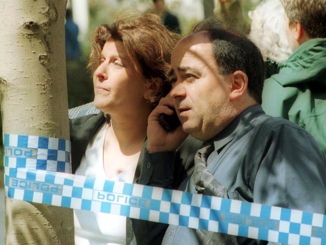 Concerned parents of students gather behind the crime scene tape as they try to call their loved ones to confirm they are okay. Picture: HWT library