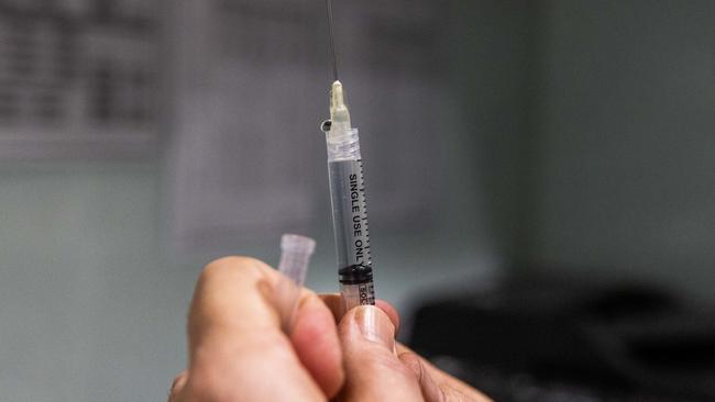 MELBOURNE, AUSTRALIA - JULY 11: A pharmacist prepares a COVID-19 vaccination booster shot for a customer at the Exhibition Pharmacy on July 11, 2022 in Melbourne, Australia. More Australians are now eligible to receive a fourth dose of a COVID-19 vaccine, after the Australian Technical Advisory Group on Immunisation (ATAGI) approved people aged 30 and above can access additional booster shots from Monday 11 July. While over 30s are now eligible for an additional dose if they choose, health authorities are strongly urging people over 50 to get the fourth COVID-19 vaccine booster and for people to wear masks indoors in public as coronavirus infections continue driven by Omicron subvariants. (Photo by Asanka Ratnayake/Getty Images)