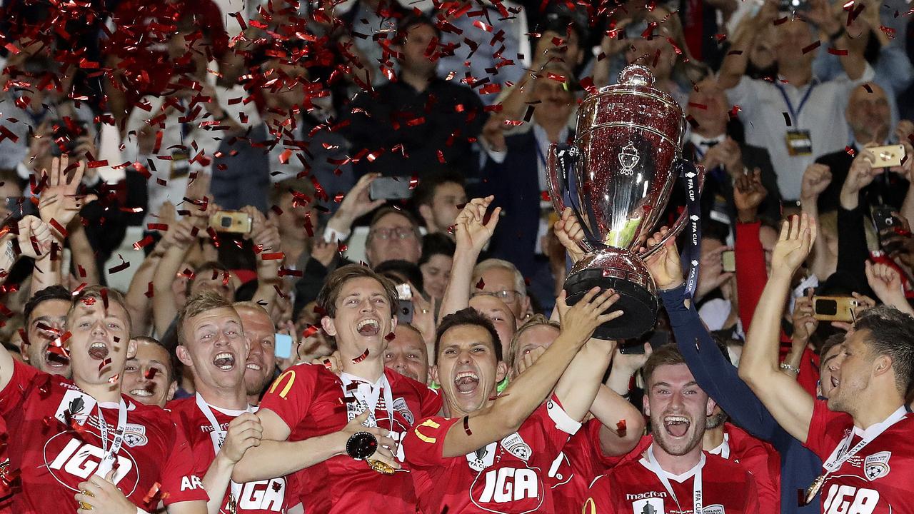 2018 champions Adelaide United celebrate with the FFA Cup Final trophy.