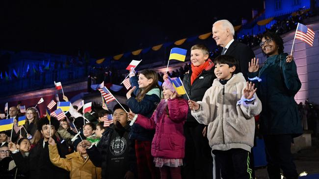 US President Joe Biden poses with children after delivering a speech at the Royal Warsaw Castle Gardens in Warsaw on February 21, 2023. (Photo by Mandel NGAN / AFP)