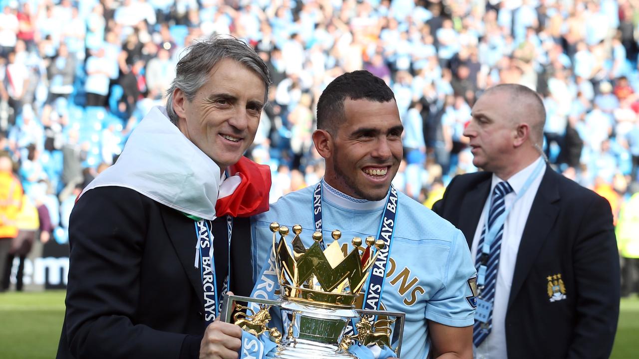 Manchester City's manager Roberto Mancini, left, and Carlos Tevez hold the English Premier League trophy May 13, 2012. (AP Photo/Jon Super)