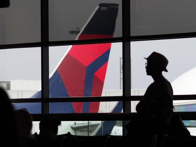 (FILES) In this file photo taken on May 04, 2017, passengers waits for a Delta Airlines flight in Terminal 5 at Los Angeles International Airport. - Delta Air Lines announced on May 14, 2020, it will retire the long-range Boeing 777 aircraft, resulting in a large write-off and deepening a likely second-quarter loss due to the coronavirus crisis. (Photo by Robyn Beck / AFP)