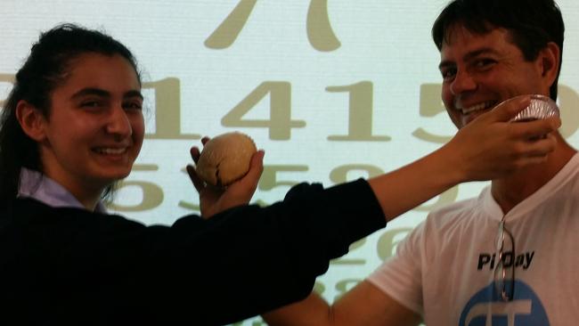 Champion Pi recital student Rona Elayan and her mathematics teacher Bryson McMillen have fun with their pies on Pi Day. Picture: Lawrence Machado