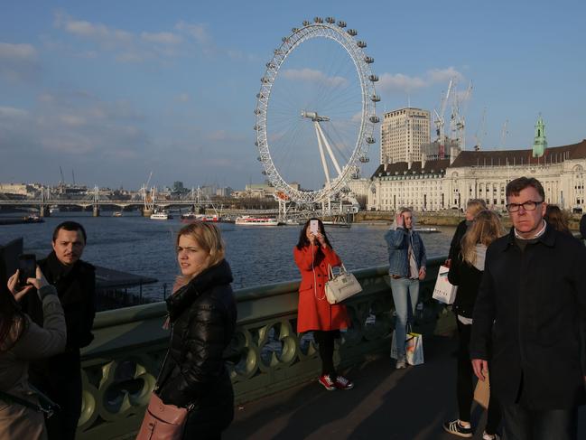 Members of the public cross Westminster Bridge with the London Eye in the background in central London on March 23, 2017 after it reopened following the March 22 terror attack at the British parliament. Picture: AFP
