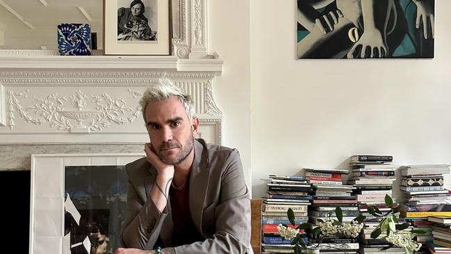 Oscar Humphries at his home in London, with a portrait of his father Barry on the mantelpiece.