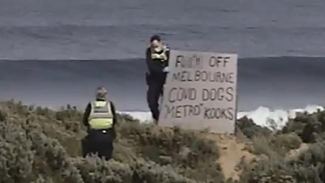 Police remove the sign from Gunnamatta Beach.