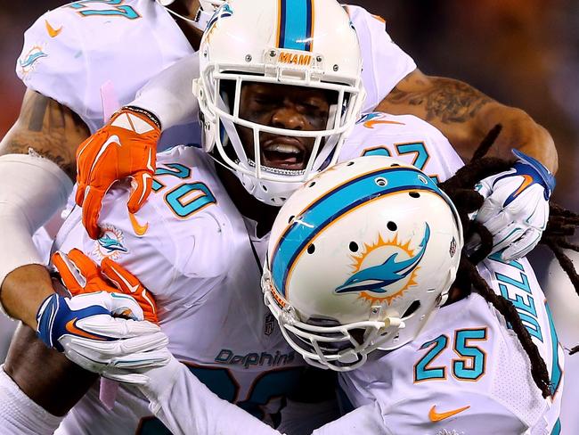EAST RUTHERFORD, NJ - DECEMBER 01: Reshad Jones #20 of the Miami Dolphins celebrates with Louis Delmas #25 and Jimmy Wilson #27 after intercepting a ball intended for Jeff Cumberland #85 of the New York Jets late in the fourth quarter during their game at MetLife Stadium on December 1, 2014 in East Rutherford, New Jersey. Elsa/Getty Images/AFP == FOR NEWSPAPERS, INTERNET, TELCOS & TELEVISION USE ONLY ==