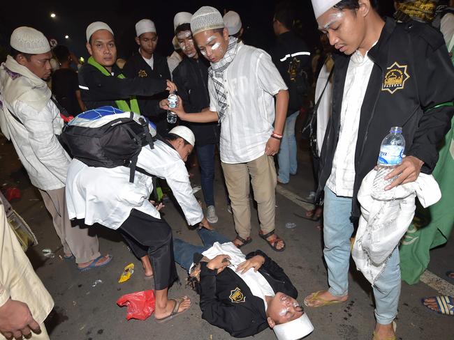 Protesters attend to an injured friend outside the presidential palace after clashes that marred an otherwise peaceful rally against governor Basuki Tjahaja Purnama. Picture: Adek Berry.
