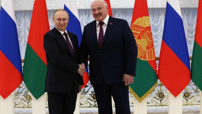 Vladimir Putin (L) and Belarusian President Alexander Lukashenko shake hands before their meeting at the Palace of Independence in Minsk. Picture: AFP.