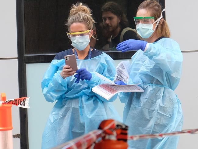 Hospital staff assist people waiting in line to be screened for COVID-19 outside the Royal Melbourne Hospital in Melbourne. Picture: Getty