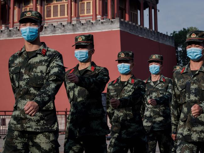 Paramilitary police officers march next to the entrance to the Forbidden City (L) after the opening session of the National People's Congress (NPC) in Beijing on May 22, 2020. - China will increase its military budget by 6.6 percent in 2020, the government announced on May 22, 2020 at the opening session of its annual National People's Congress in Beijing. (Photo by NICOLAS ASFOURI / AFP)