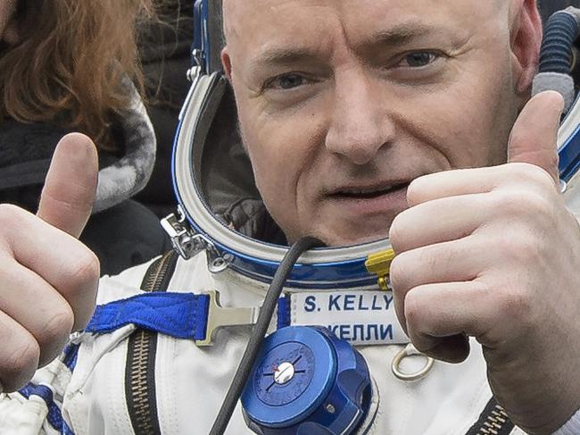 In this photo provided by NASA, International Space Station (ISS) crew member Scott Kelly of the U.S. gestures after landing near the town of Dzhezkazgan, Kazakhstan, on Wednesday, March 2, 2016. The Soyuz TMA-18M spacecraft landed with Expedition 46 Commander Kelly of NASA and Russian cosmonauts Mikhail Kornienko and Sergey Volkov of Roscosmos. Kelly and Kornienko are completing an International Space Station record year-long mission to collect valuable data on the effect of long duration weightlessness on the human body that will be used to formulate a human mission to Mars. Volkov is returning after six months on the station (Bill Ingalls/NASA via AP)
