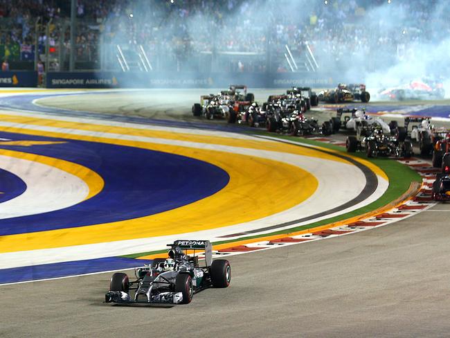 SINGAPORE - SEPTEMBER 21: Lewis Hamilton of Great Britain and Mercedes GP leads the field out of turn two as Fernando Alonso of Spain and Ferrari runs wide and drivers lock up during the Singapore Formula One Grand Prix at Marina Bay Street Circuit on September 21, 2014 in Singapore, Singapore. (Photo by Mark Thompson/Getty Images)