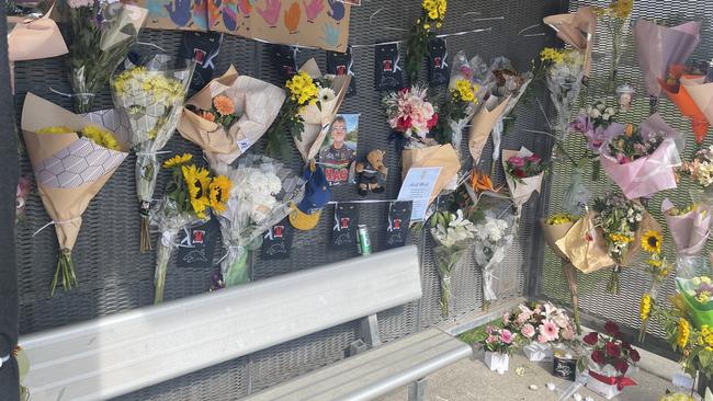 The memorial for Michael Warburton at a bus stop on Kianawah Rd where the Brisbane man was killed in a tragic hit and run crash.