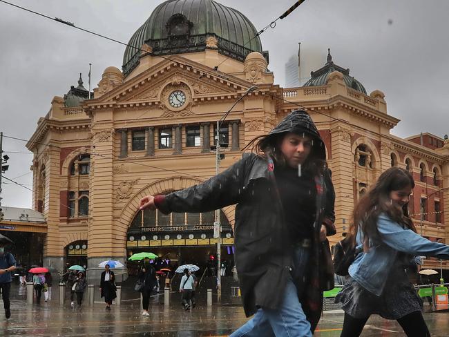 Saturating rain hits Melbourne mid-summer. Avoiding puddles at Flinders st. Picture: Alex Coppel.