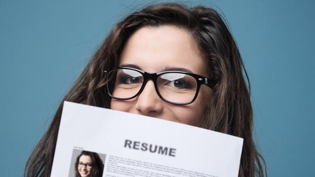 Young woman hiding behind her resume.