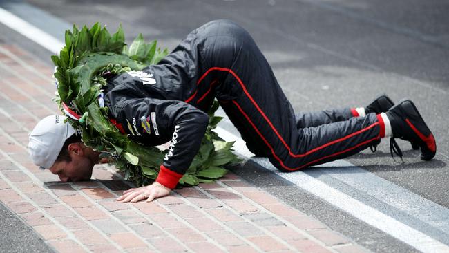 Australia’s Will Power celebrates by kissing the yard of bricks after winning the Indianapolis 500