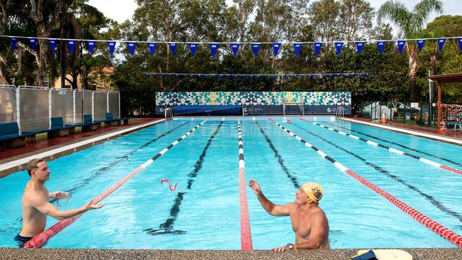 Vince Bird, right, and another swimmer talk in dedicated lanes in an outdoor pool at Boy Charlton Pool in North Manly on May 15. Picture: Cameron Spencer.