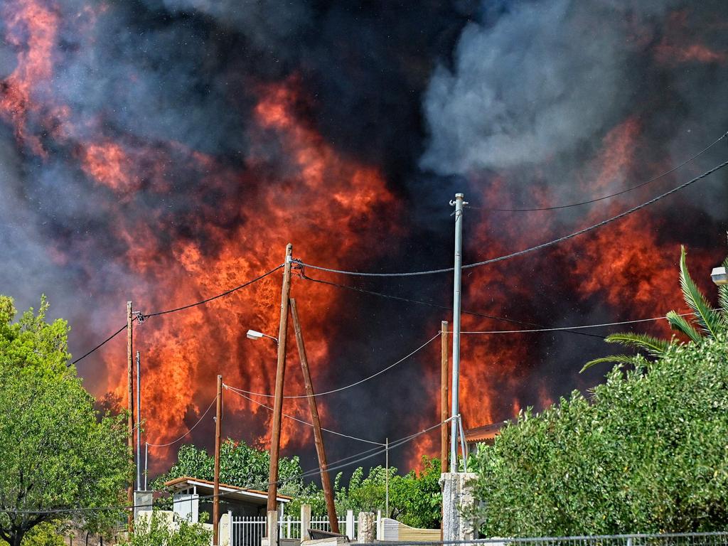 Wildfire rages by the houses in the settlement of Irini, near the resort town of Loutraki. Picture: AFP