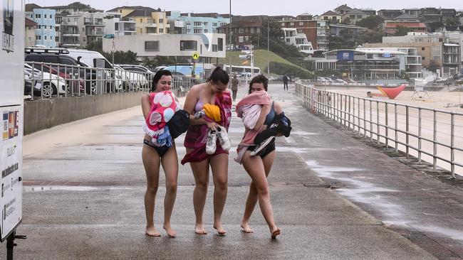 Beachgoers cop the wild wet weather in Bondi Beach. Picture: Flavio Brancaleone