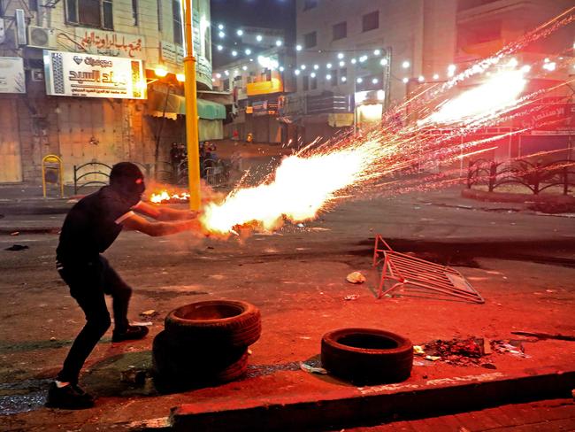 A Palestinian protester launches flares amid clashes with Israeli soldiers in the city of Hebron in the occupied West Bank. Picture: AFP