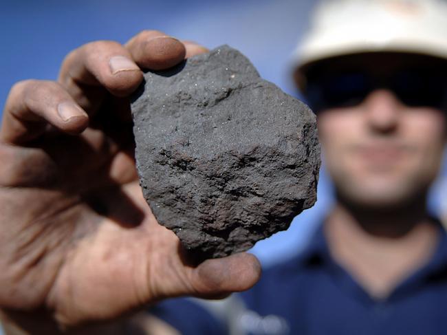 01/01/2009 BUSINESS: Rio Tinto Group worker Duncan Pratt holds a piece of high grade iron ore, showing hemalite crystals, at the Tom Price iron ore mine in Pilbara, north Western Australia on Wednesday, July 26, 2006. BHP Billiton Ltd., the world's largest mining company, is losing the support of investors and steelmakers for its proposed $128 billion takeover of Rio Tinto Group. Photographer: Jack Atley/Bloomberg News