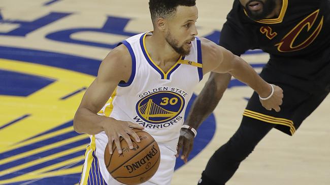 Stephen Curry dribbles against the Cleveland defence. Picture: AP