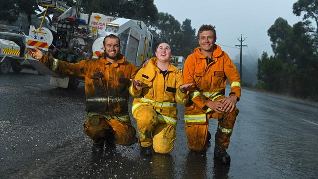 CFS volunteers Nick Svetec from Barmera, Hayllee Camplbell from Morgan CFS and Joel Trace from Barmera CFS celebrate the rain providing relief to the Cherry Gardens fire. Pictured outside the Bradbury Country Fire Service station. Picture: Tom Huntley