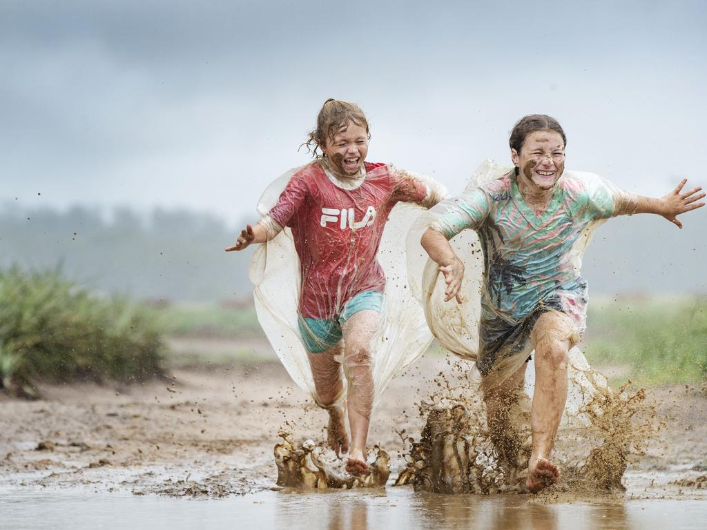 Sisters Kasey 8, and Jessica Hewitt 10, play in the rain on their family Pineapple and Raspberry farm at Wamuran. Photo Lachie Millard