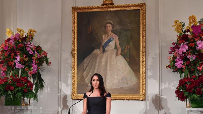 Standing in front of a portrait of the Queen, Meghan Markle told a reception at Government House in Wellington, New Zealand “feminism is about fairness”. Picture: Marty Melville/AAP