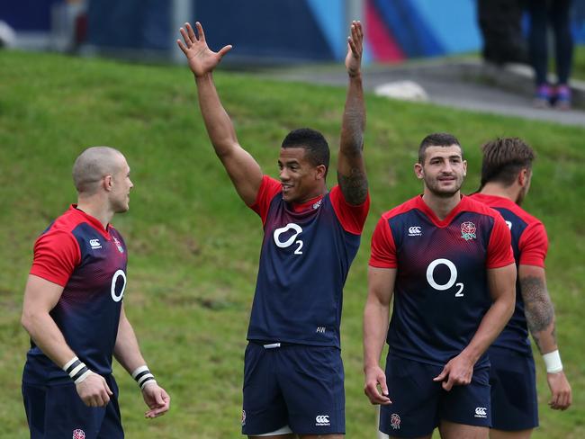 Anthony Watson celebrates with team mates Mike Brown (L) and Jonny May during an England training session.