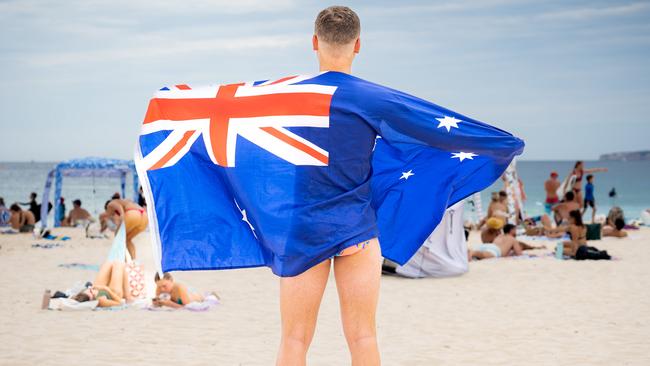 An Australia Day supporter flies the flag at Bondi Beach. Picture: Tom Parrish