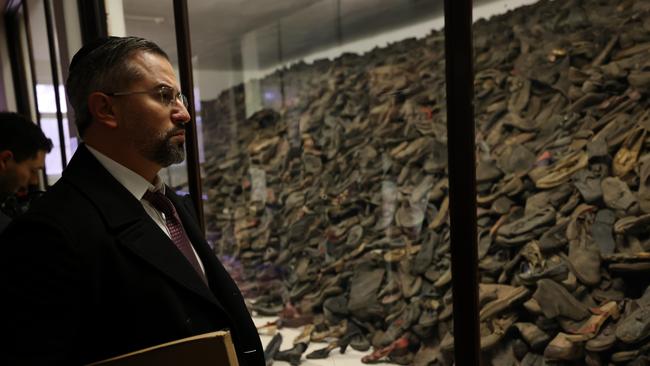 Eitan Neishlos at Auschwitz-Birkenau with some of the 8000 shoes belonging to children murdered by the Nazis. Picture: Neishlos Foundation