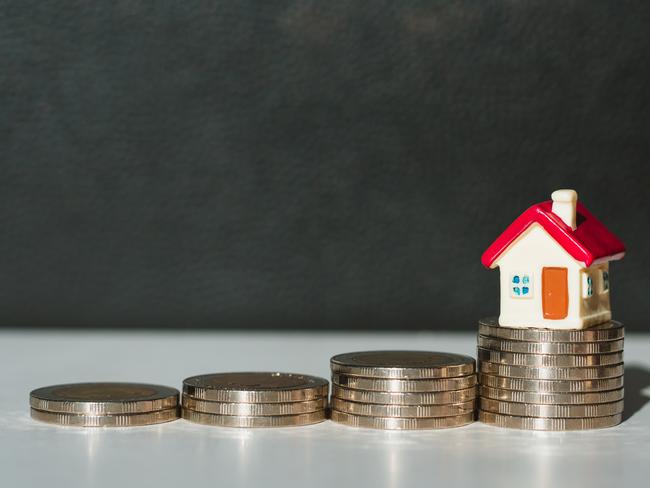 Miniature colorful house on pile of coins using as property and financial concept