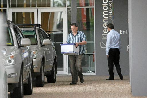 Brothers Andrew and Bradley Young remove files from the company headquarters. Picture: Brett Wortman