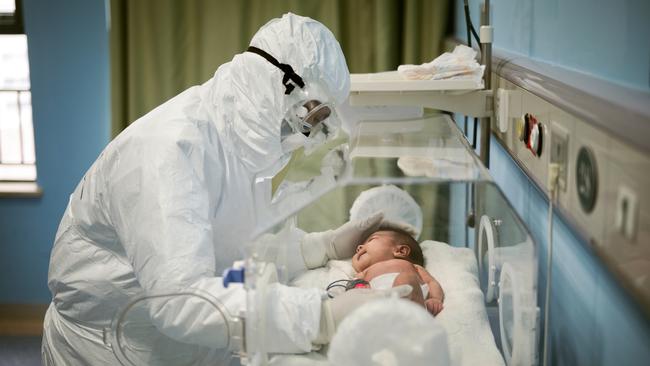 A medical staff attends to a baby with novel coronavirus at the Wuhan Children’s Hospital, in Wuhan.