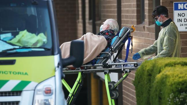 A resident leaves Menarock LIFE Aged Care in Essendon in a patient transport ambulance. Picture: Ian Currie