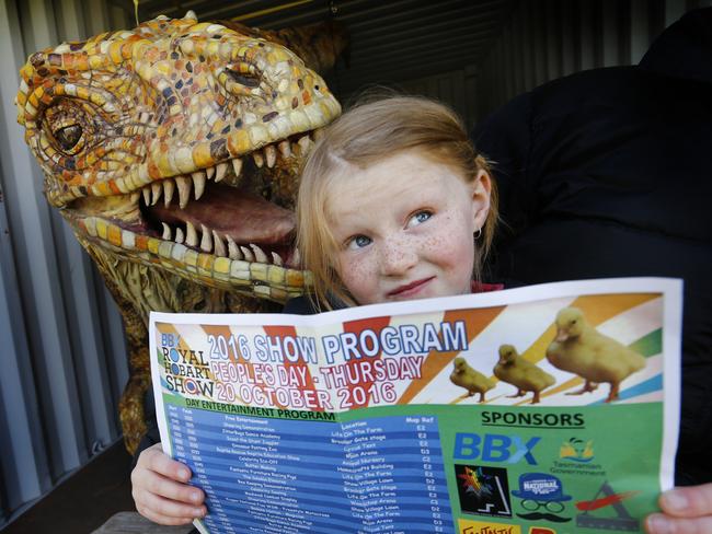 Wednesday show preview, picture of champion pony rider Matilda Cameron 6 form Launceston reading the show program watched by the Austral Ovenator dinosaur.,picture;KIM EISZELE