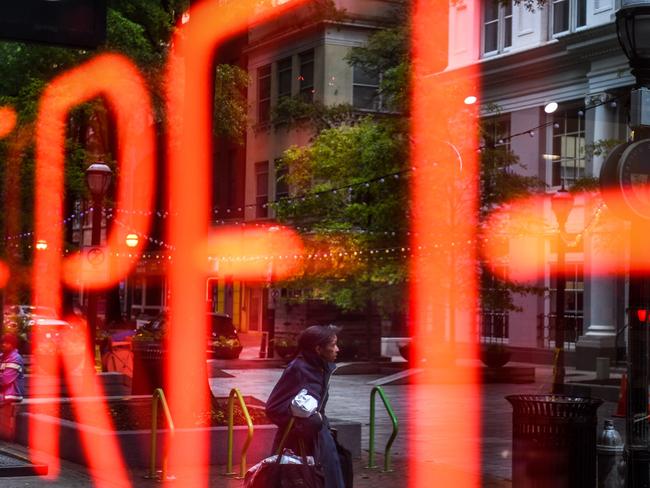 Homeless people are reflected in the window of a sandwich shop, reading "free", in downtown Atlanta, Georgia. Picture: AFP