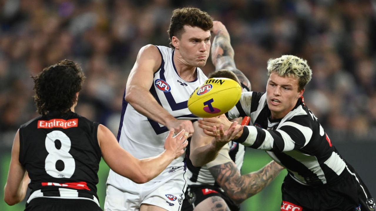 MELBOURNE, AUSTRALIA - SEPTEMBER 10: Blake Acres of the Dockers handballs whilst being tackled by Jack Ginnivan of the Magpies during the AFL First Semifinal match between the Collingwood Magpies and the Fremantle Dockers at Melbourne Cricket Ground on September 10, 2022 in Melbourne, Australia. (Photo by Quinn Rooney/Getty Images)